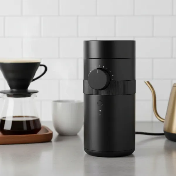 Fellow Opus conical burr grinder on a kitchen counter, showcasing its sleek design and key features.