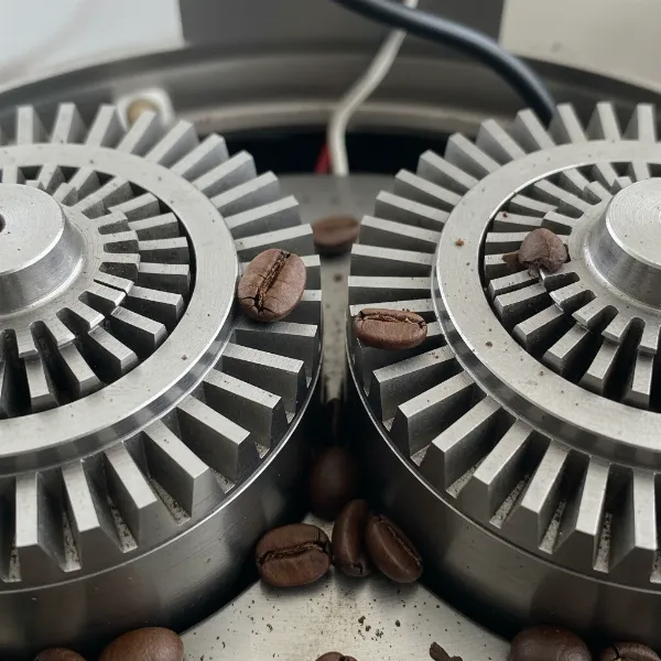 Close-up of flat burrs inside a coffee grinder showing their parallel design and sharp teeth.